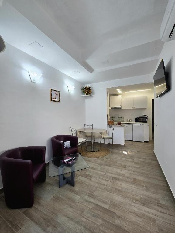 a living room with a table and chairs and a kitchen at La Casina in Follonica