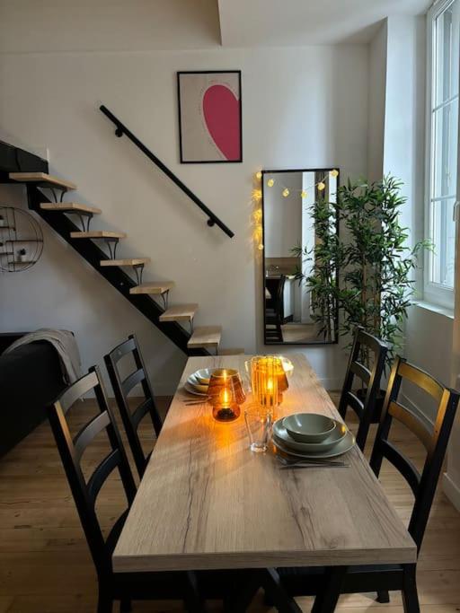 - une table en bois dans une pièce avec des chaises et un escalier dans l'établissement Studio cosy au cœur de ville, mezzanine -203-, à Saint-Étienne