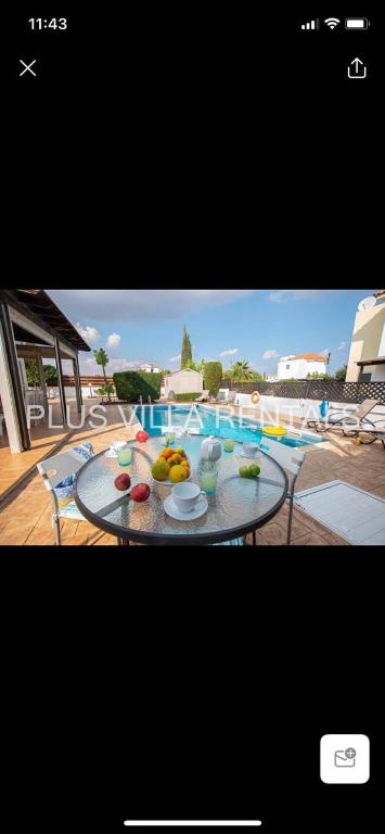 a table with fruit on it next to a swimming pool at Villa 4 in Ayia Thekla in Ayia Napa