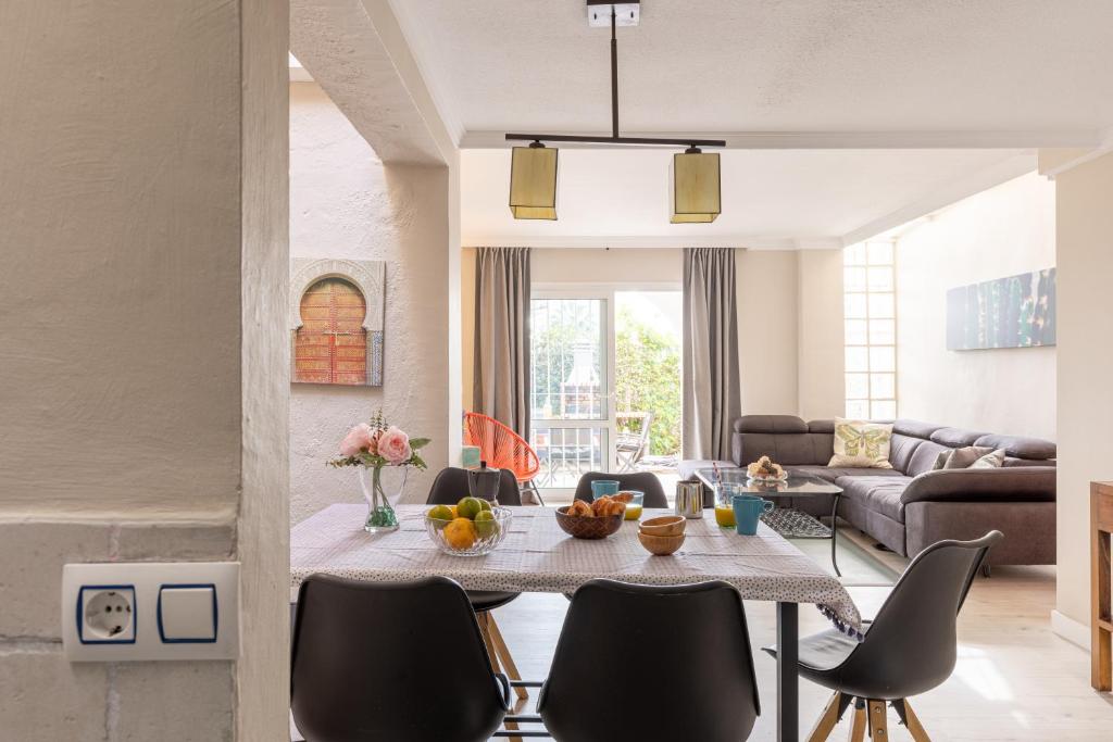 a living room with a table and chairs at Charming house next to the sea in Benalmádena