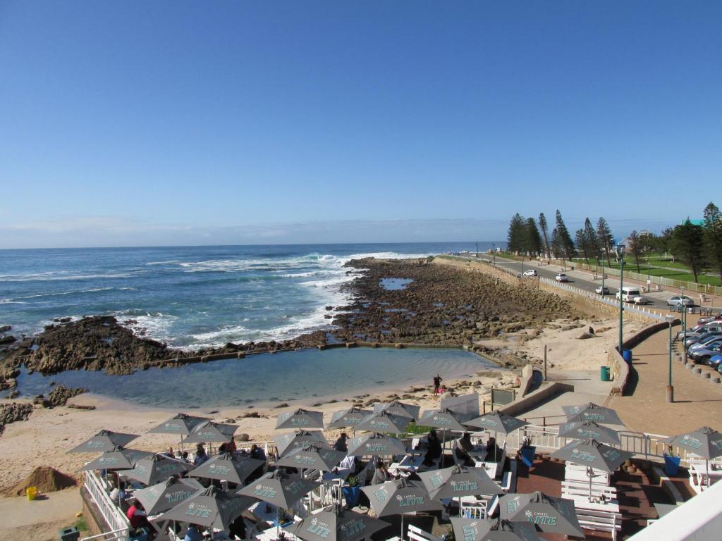 a beach with a bunch of buildings and the ocean at Point Village Accommodation - Stephen in Mossel Bay