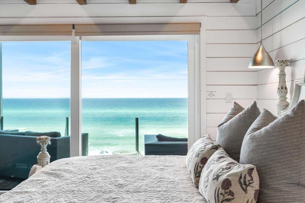 a bedroom with a bed and a view of the ocean at The Good Life in Inlet Beach