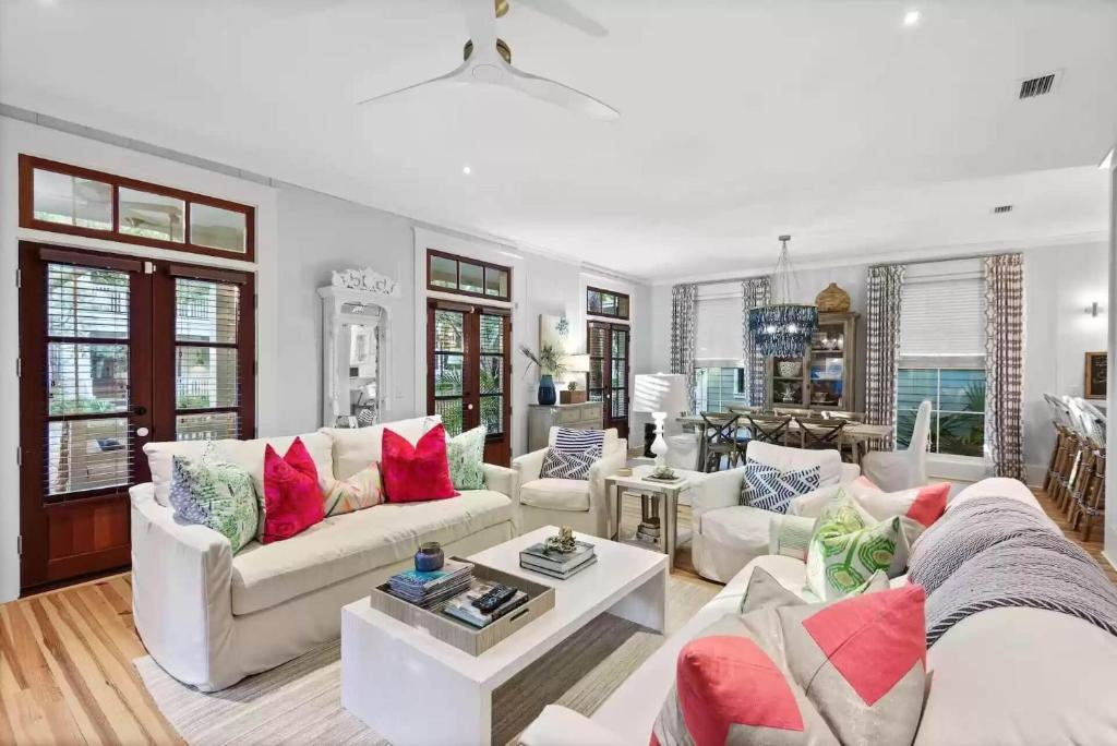 a living room with white furniture and red pillows at Southern Charm in Santa Rosa Beach