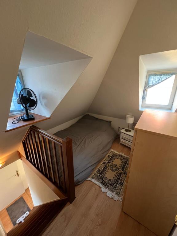 Cette chambre mansardée comprend un lit et un escalier. dans l'établissement Hyper Centre Strasbourg, à Strasbourg