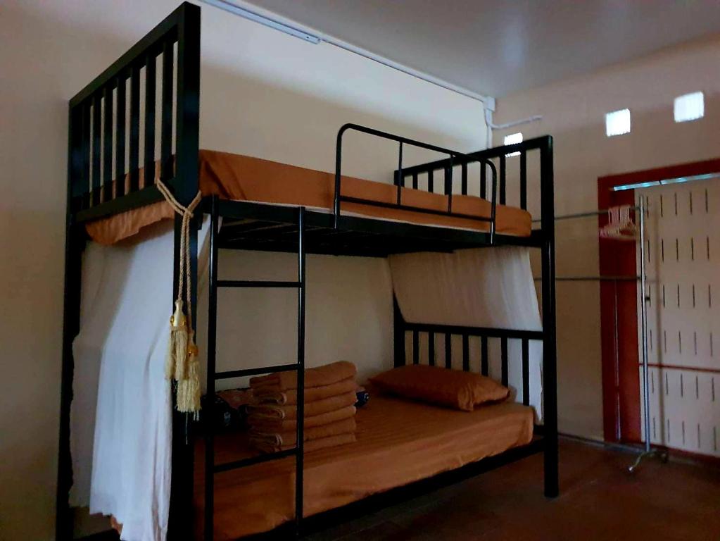 a bedroom with two bunk beds in a room at Rainy's house ห้องพักขนาดใหญ่สำหรับครอบครัวและกลุ่มเพื่อน เงียบสงบและอบอุ่นใจกลางย่านนิมมาน in Chiang Mai