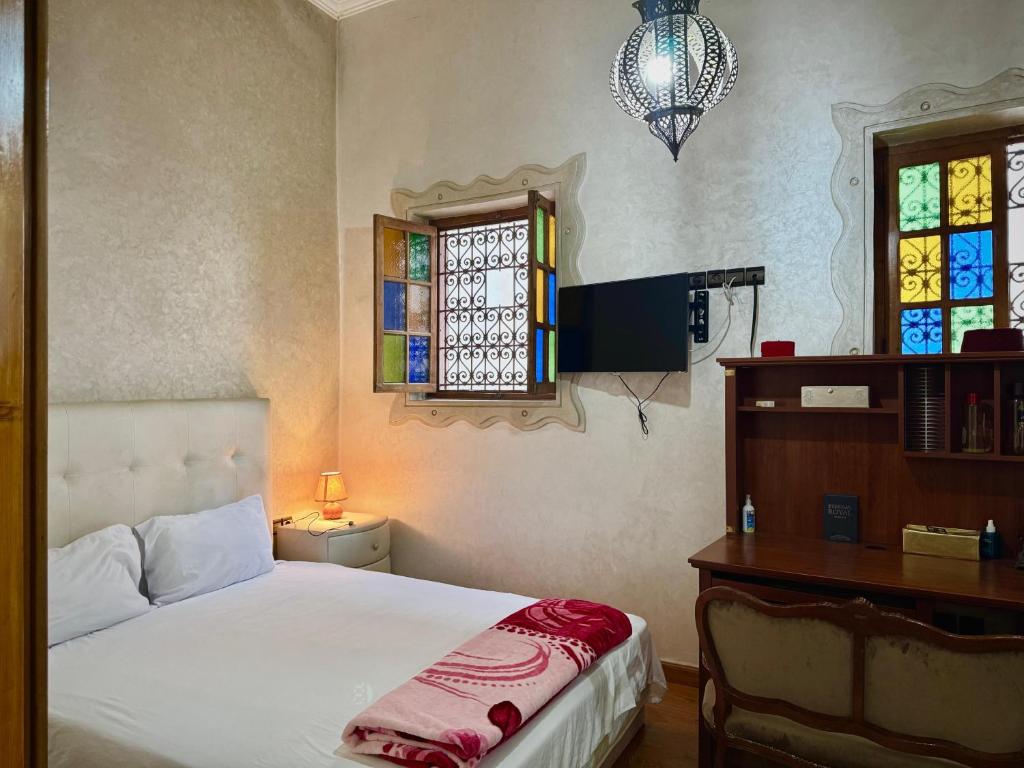 une chambre avec un lit, un bureau et une fenêtre dans l'établissement Riad Saffron, à Rabat