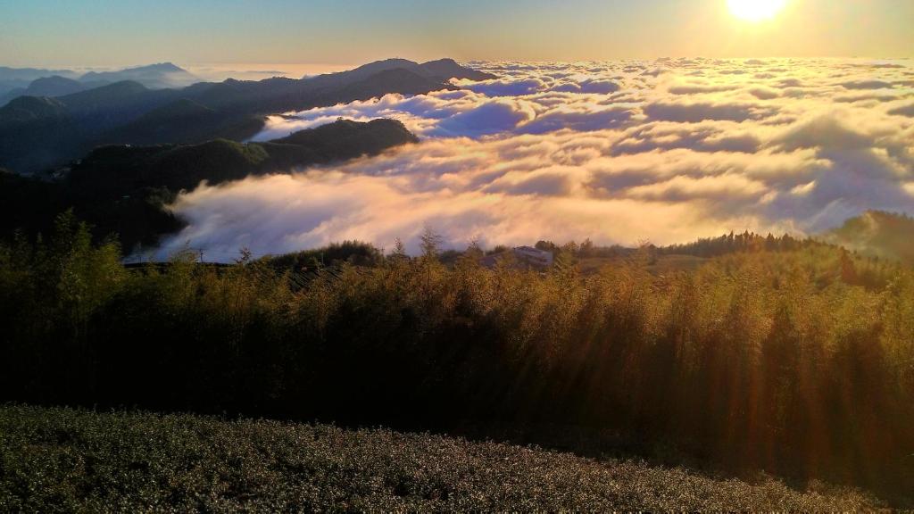 a view of the sun rising above a sea of clouds at Cuiti B&B in Fenqihu