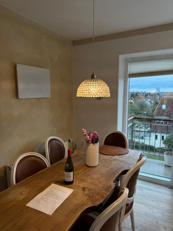 a dining room table with a bottle of wine and flowers at Lejlighed kbh in Copenhagen
