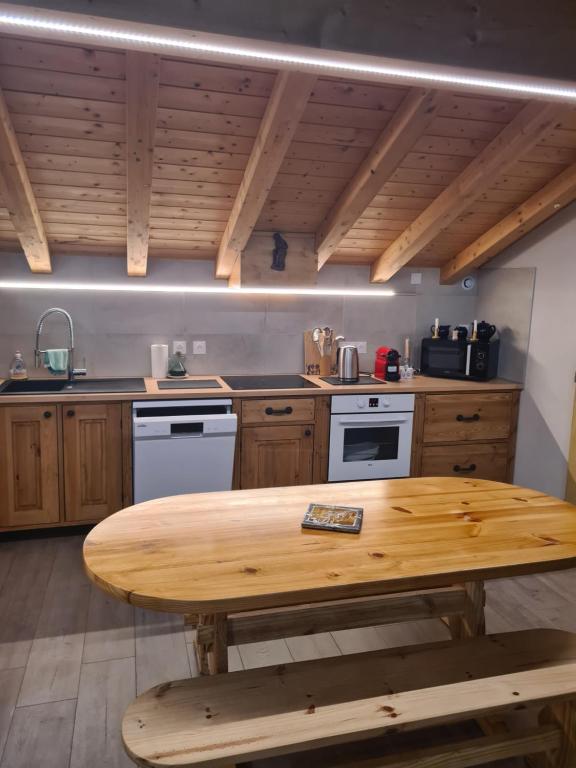 une cuisine avec une table en bois au milieu dans l'établissement Appartement luxueux seez, à Séez
