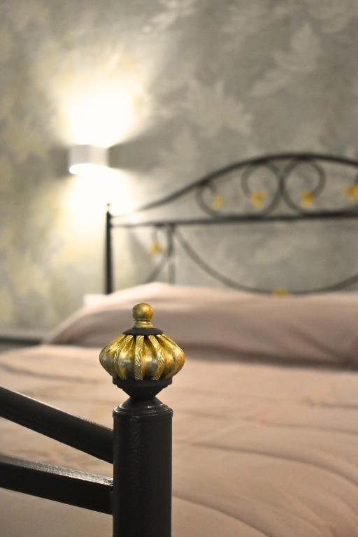 a bed with a black frame and a gold knob at Dolce Vita House in Pontecagnano