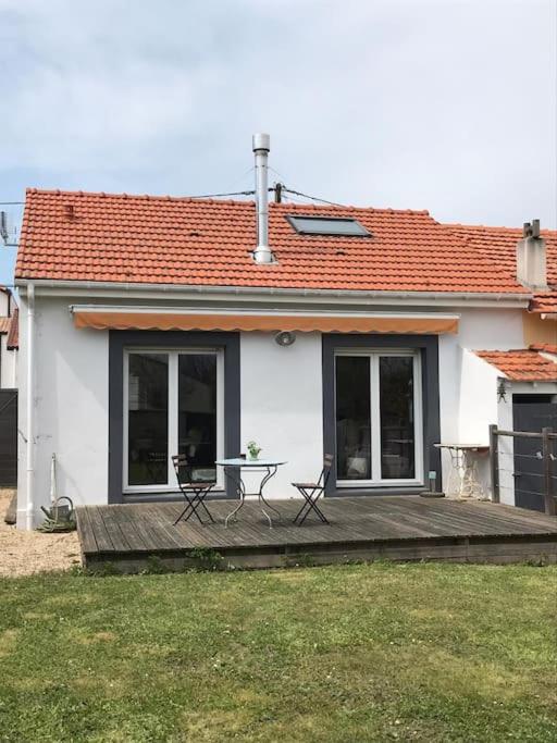 une maison avec une terrasse avec une table et des chaises dans l'établissement Petite maison cosy, à Pornic