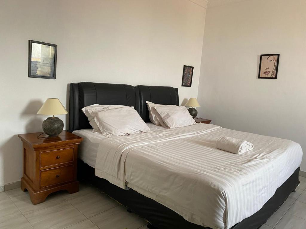 a bedroom with a large bed with white sheets and pillows at SEROJA RAYA GUEST HOUSE in Jepara
