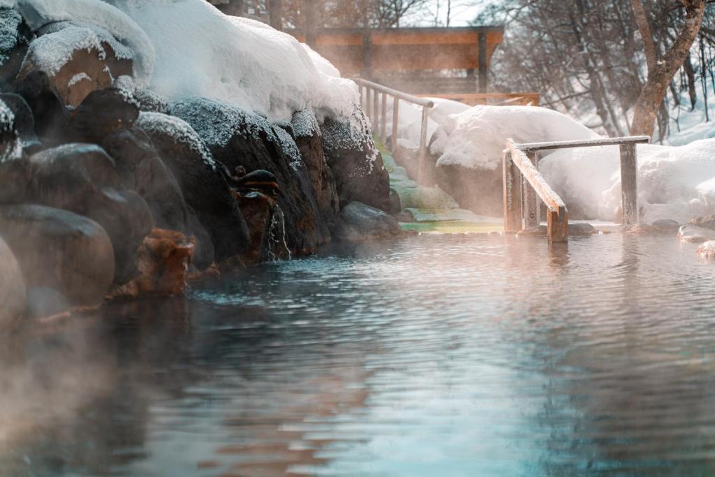 a pool of water with snow on the side of it at Yuyado DAIICHI in Naka-shibetsu