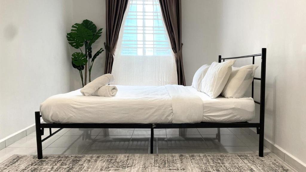 a bed with white sheets and pillows in a bedroom at ANJUNG KASEH Villa Bukit Katil 4bedroom with Swimming Pool in Melaka