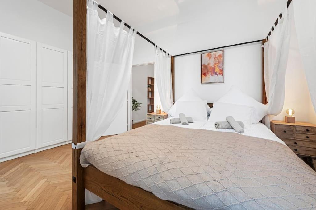 a bedroom with a large bed with white walls at Comfortable 2 Bedroom Apartment in Vienna