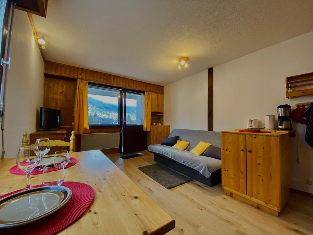 un salon avec un canapé et une table dans l'établissement Studio cosy au cœur de Samoëns, proche commerces et ski bus, balcon, parking, animaux acceptés - FR-1-624-157, à Samoëns