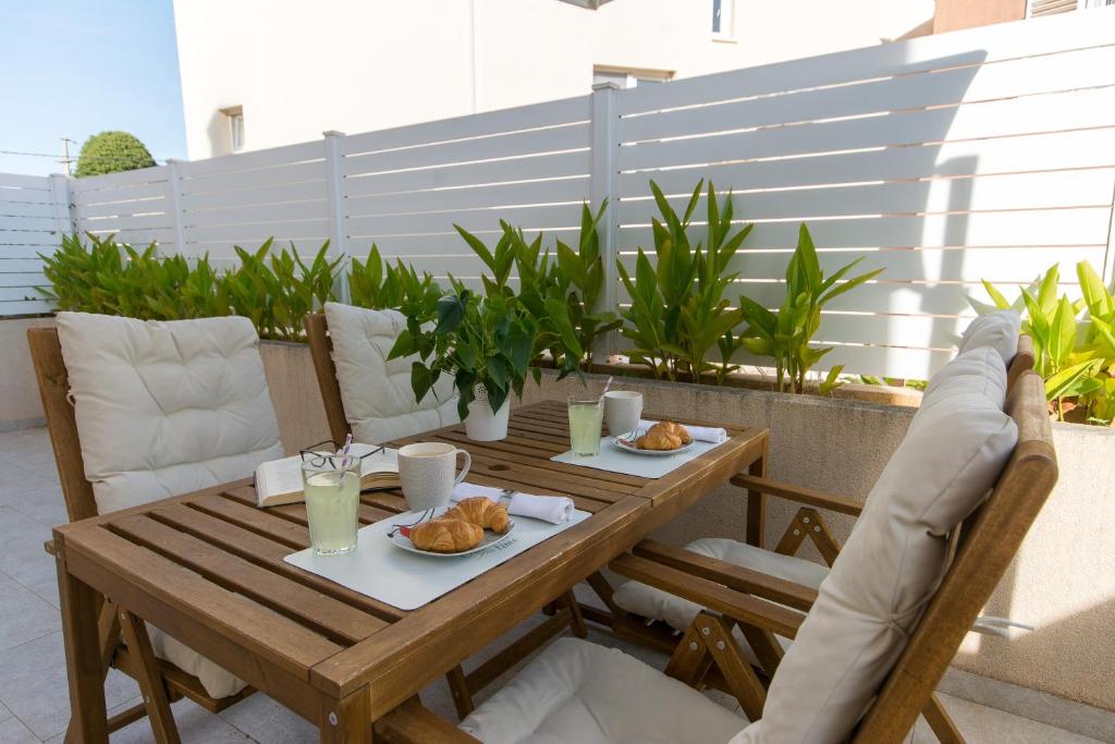 een houten tafel met twee borden met eten op een terras bij Apartments D&D in Dubrovnik