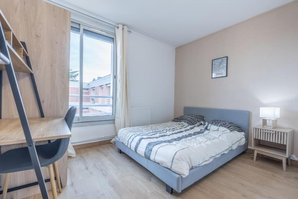 une chambre avec un lit, un bureau et une fenêtre dans l'établissement Le Cosmopolitan T6 10 personnes, à Toulouse
