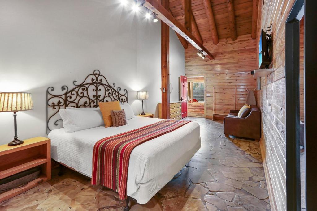 a bedroom with a bed and a tv in a room at Wimberley Log Cabins Resort and Suites- Unit 3 in Wimberley