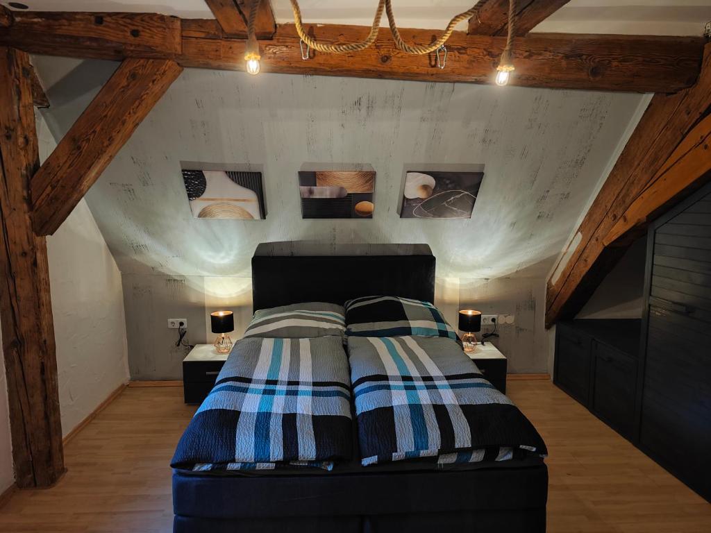 Schlafzimmer mit einem Bett mit gestreifter Decke in der Unterkunft Appartement Sittenbach "Love" in Kirchensittenbach
