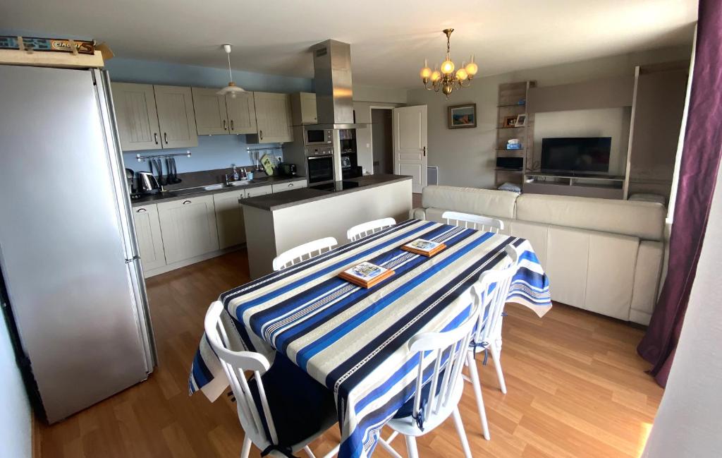 une cuisine avec une table et des chaises bleues et blanches dans l'établissement Appartement avec WIFI, balcon au centre de PERROS-GUIREC - Réf 959, à Perros-Guirec