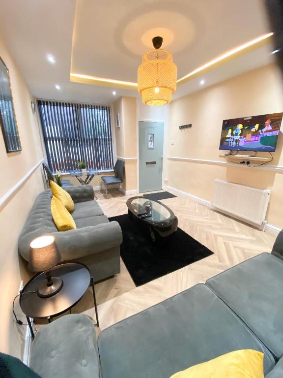 a living room with a couch and a tv at St James - Beautifull house next to city centre in Killingbeck