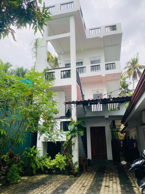 a tall white building with a courtyard in front of it at Villa Mangofera in Galle