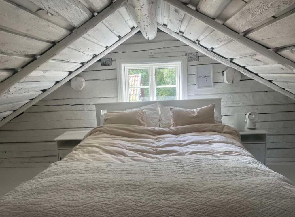 une chambre avec un grand lit blanc avec une fenêtre dans l'établissement Vinterhus nära Romme Alpin, à Borlänge