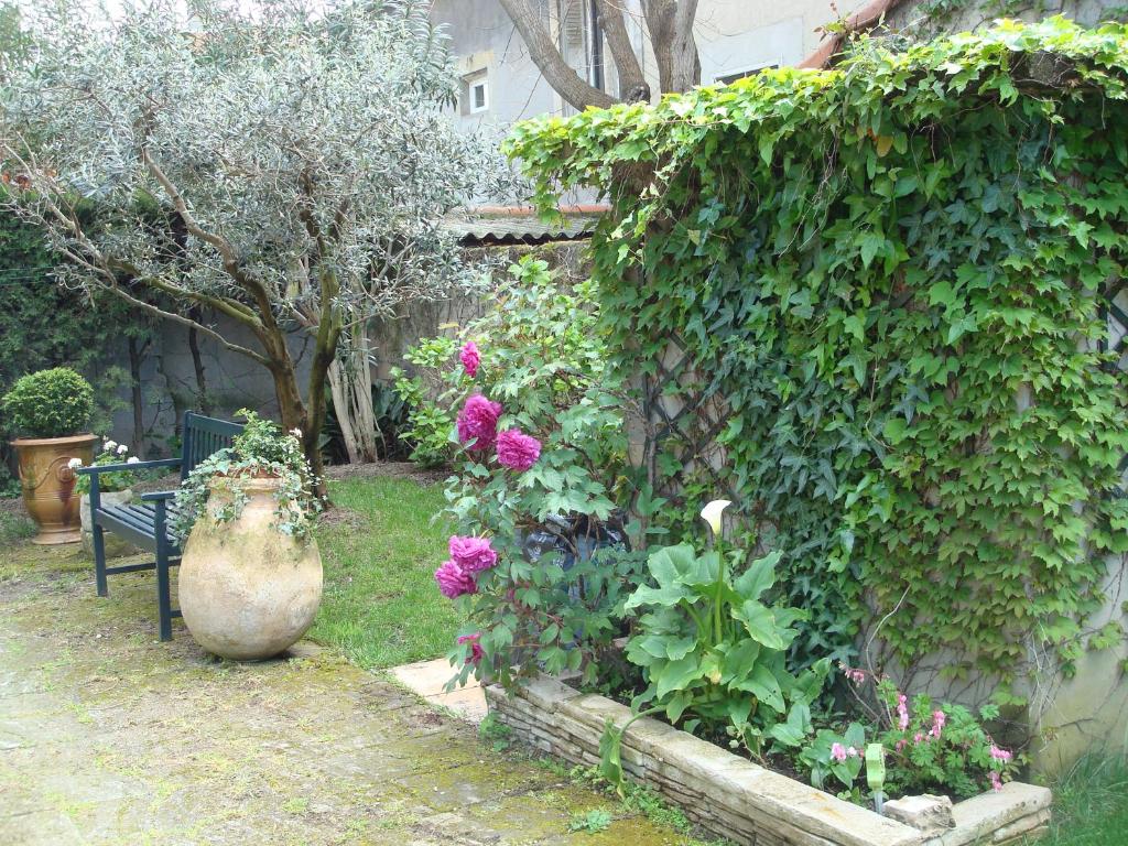 ogród z wazą, kwiatami i ławką w obiekcie Arles les Alyscamps w mieście Arles