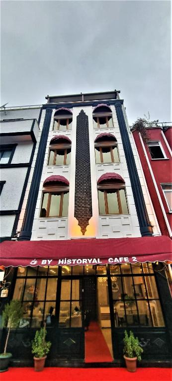a tall white building with a red awning at By Historial Hotel Due in Istanbul