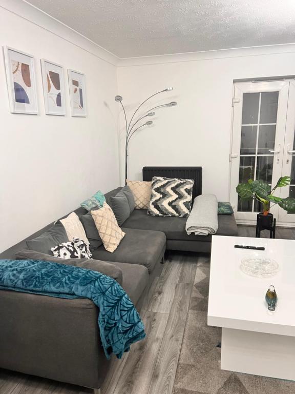 een woonkamer met een bank en een tafel bij Lovely tidy and well decorated en-suite king sized bedroom in a shared 2 bedroom flat in Belle Isle