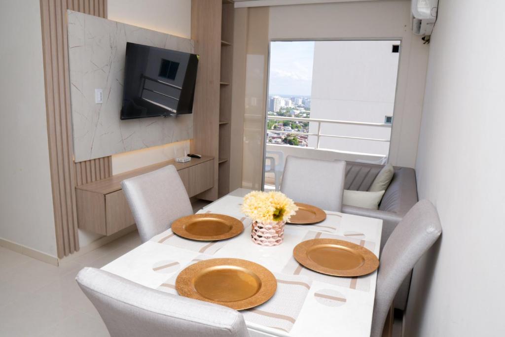 a dining room with a table with chairs and a television at Vista panoramica al Mar y Piscina in Cartagena de Indias
