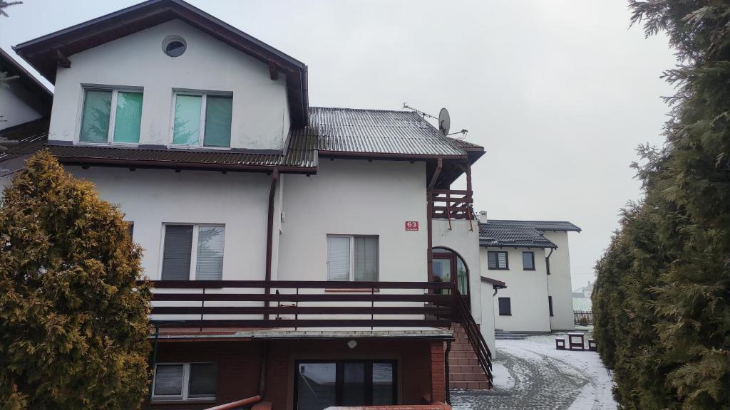 a large white house with snow on the ground at IWA Noclegi dla pracowników in Moczadła