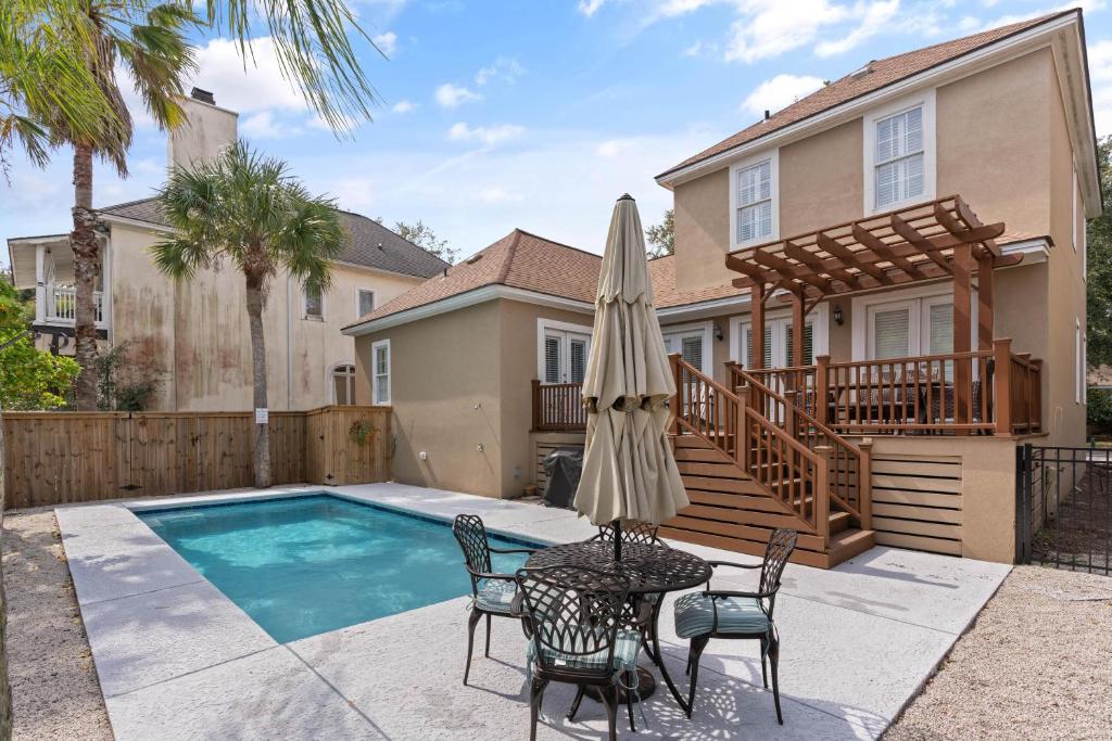 ein Haus mit einem Pool und einem Tisch mit einem Sonnenschirm in der Unterkunft Village Retreat - 100 Mews Circle in King City