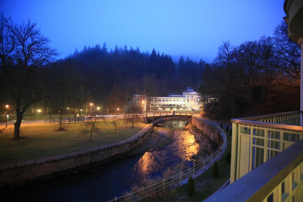 a bridge over a river in a city at night at Slunecni Lazne Apartments in Karlovy Vary