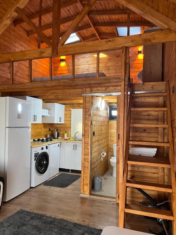 a kitchen with white appliances and a ladder in a cabin at Urla Bungalov Evleri in Urla