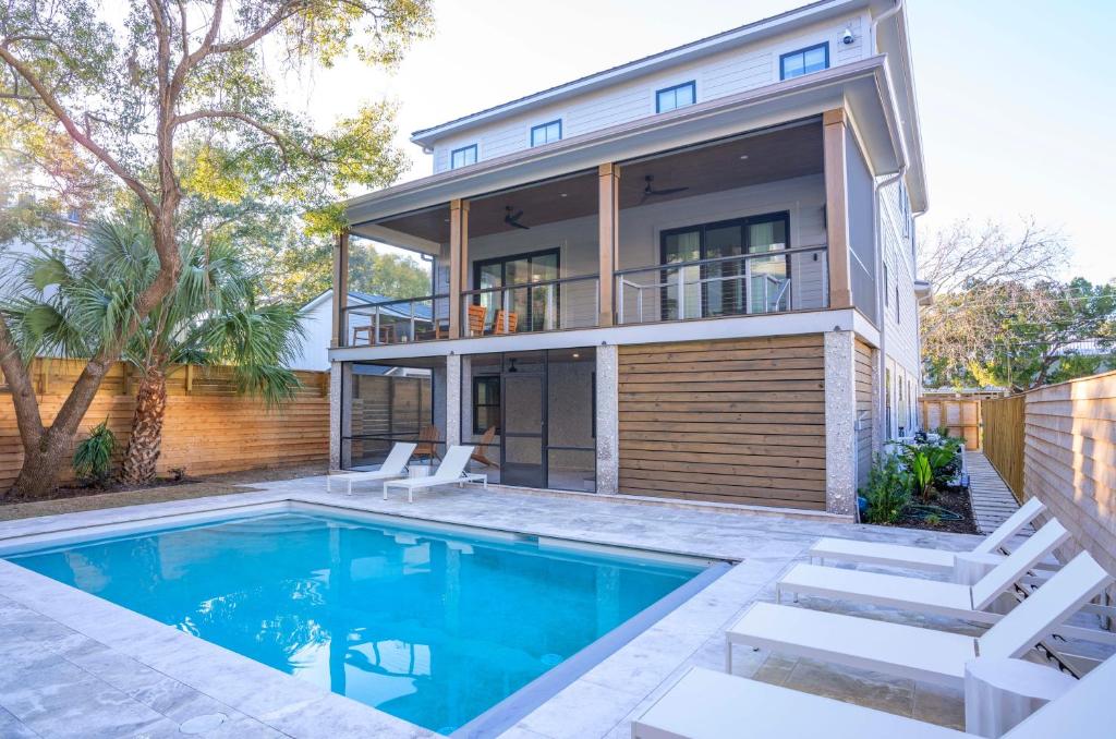 una casa con piscina delante de una casa en The Ship's Belle - 912 Ocean Blvd, en Saint Simons