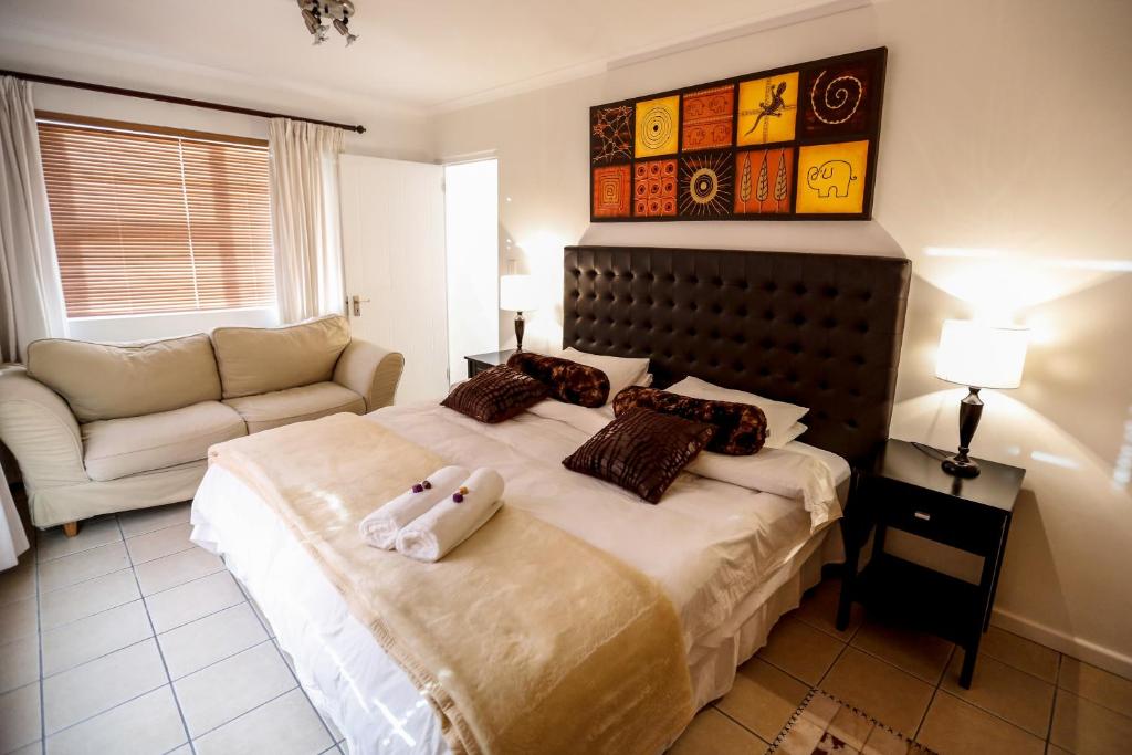 a bedroom with a bed with a stuffed animal on it at Secret Garden Guesthouse in Bloubergstrand