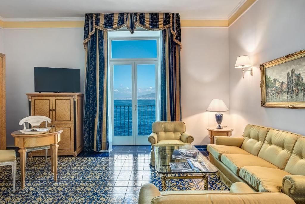 a living room with a couch and a large window at Imperial Hotel Tramontano in Sorrento
