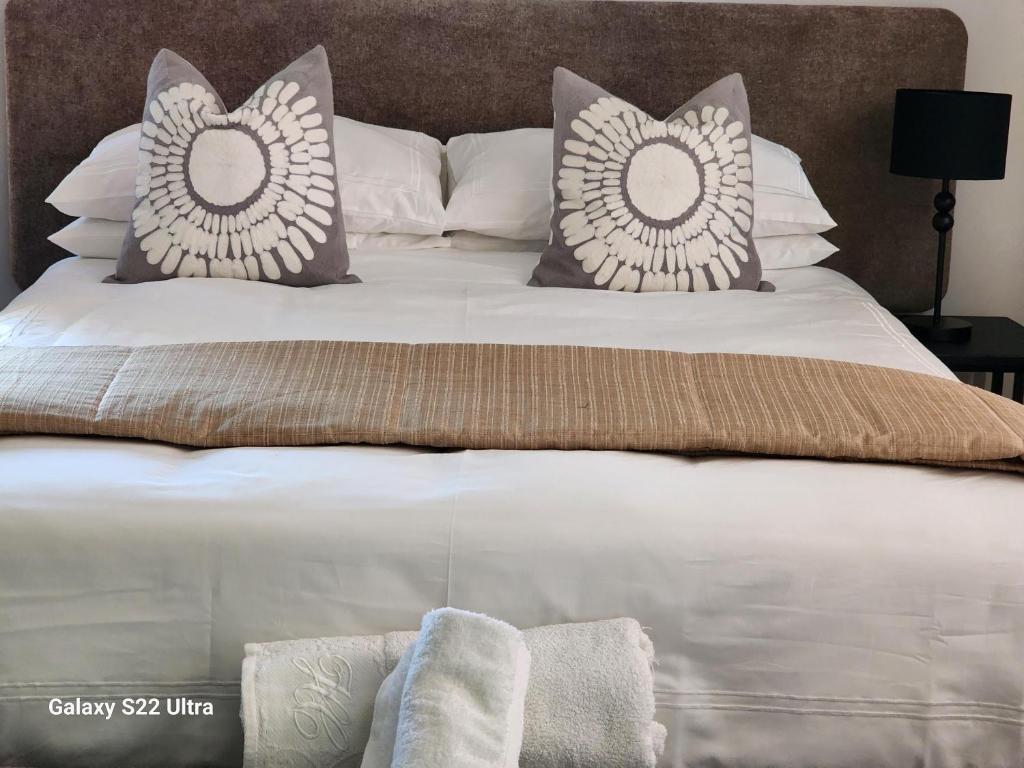 a large white bed with pillows on top of it at Oblique Boutique House in Centurion