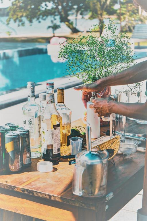 a table with bottles of alcohol on it next to a pool at Vung Bau Resort in Phú Quốc
