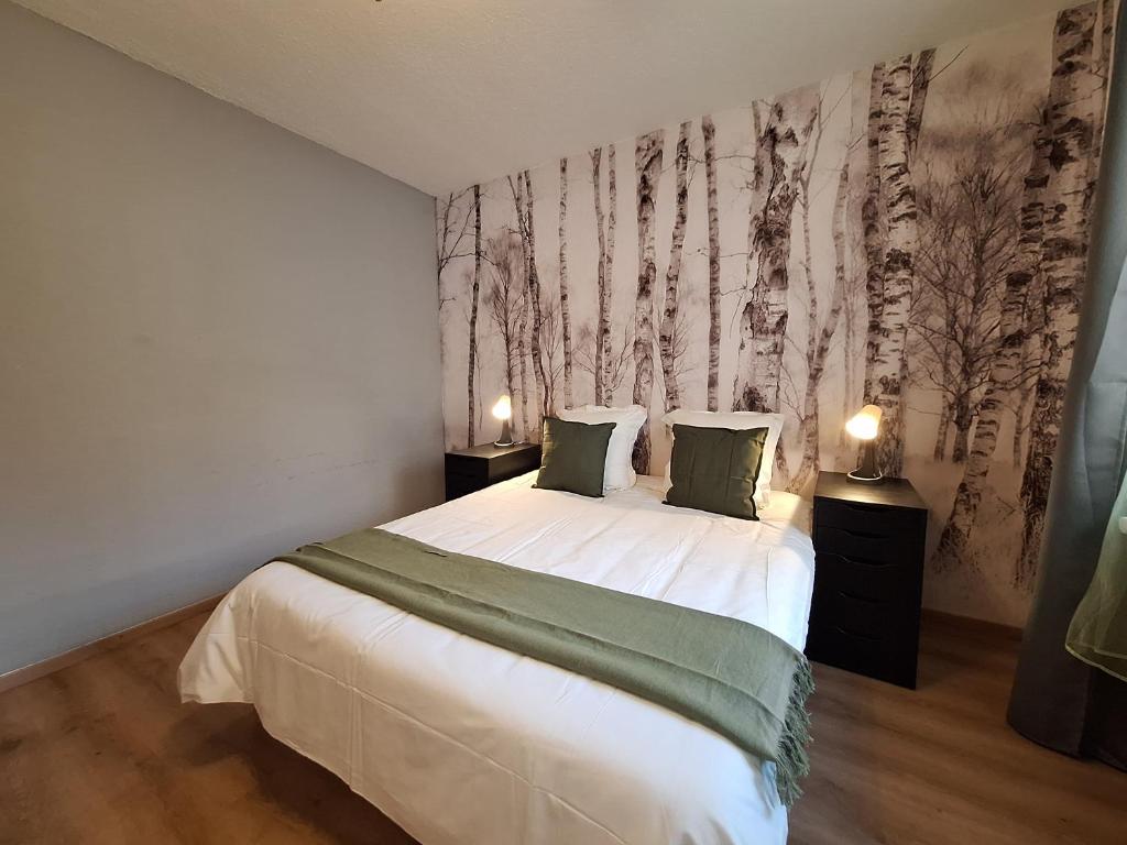 - une chambre avec un lit et un mur arboré dans l'établissement Le Kuttel Colmar Centre Historique, à Colmar