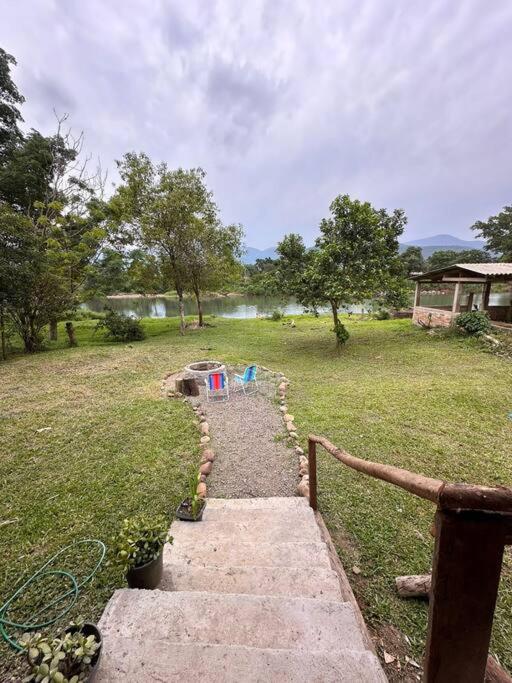a path leading into a field with a fence at Casa na beira do rio com Lareira in Itati