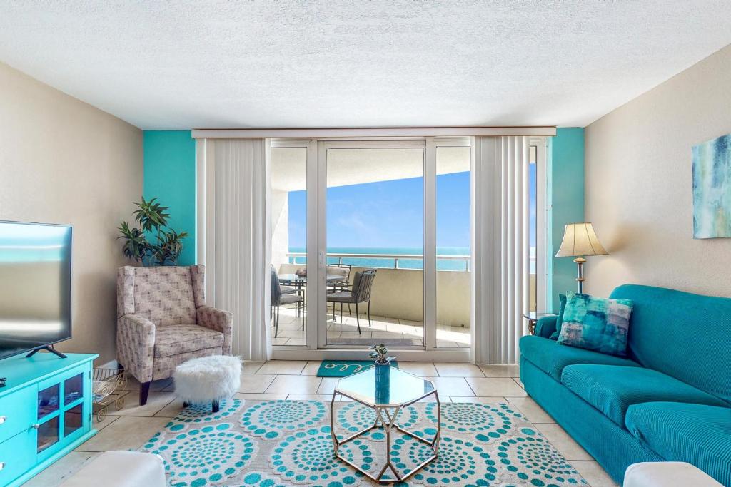a living room with a blue couch and a view of the ocean at Perdido Sun 612 in Perdido Key