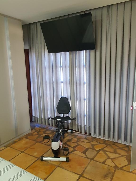 ein Zimmer mit einem Stuhl und einem Flachbildfernseher in der Unterkunft Casa Colorida em Touros in Touros