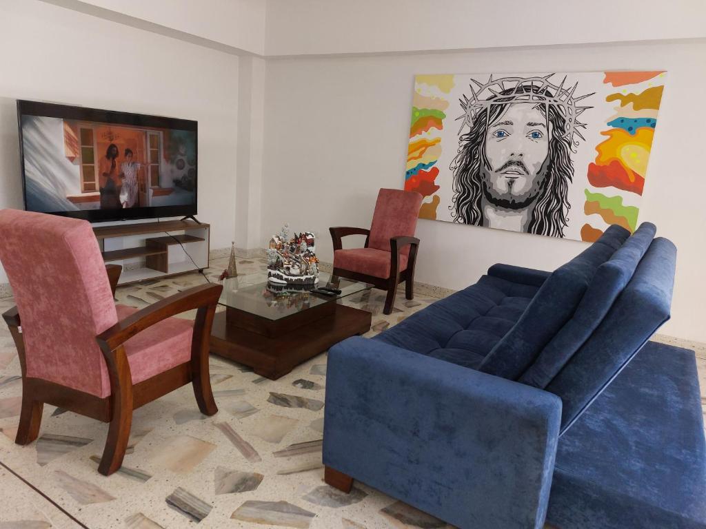 a living room with a blue couch and a tv at Apartamento en el Centro de Roldanillo 5 habitaciones 9 camas 4 baños in Roldanillo