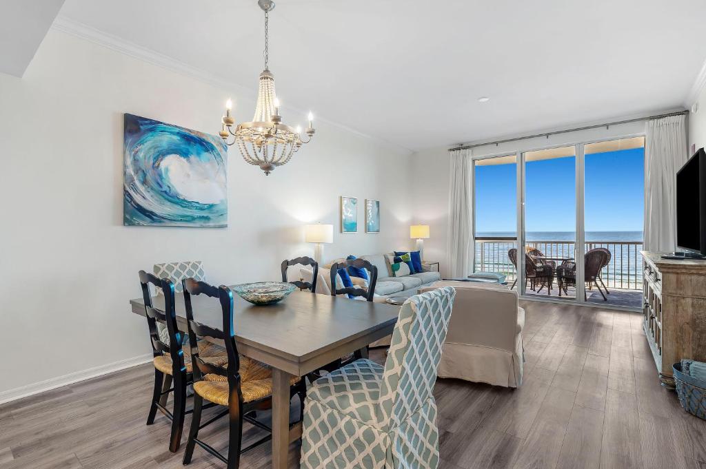 a dining room and living room with a table and chairs at Spanish Key 604 in Perdido Key
