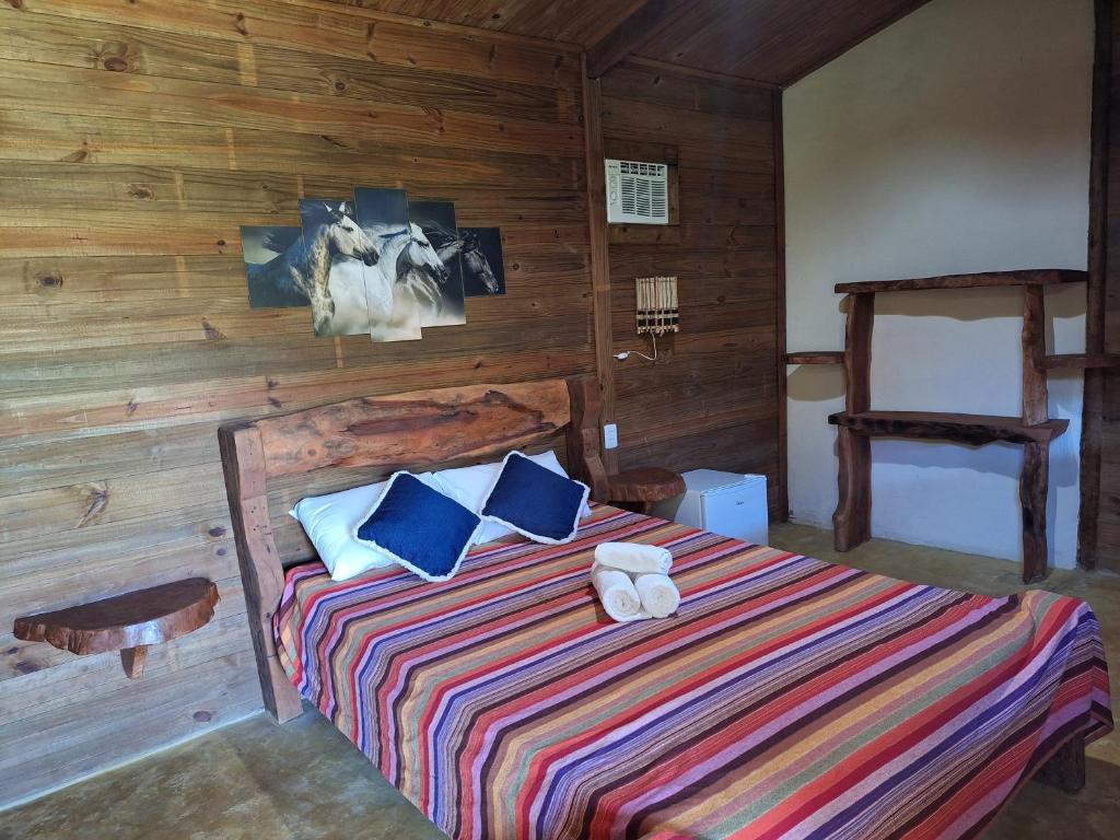 a bedroom with a bed with blue pillows at Pousada Rancho Sêmani in Itacaré