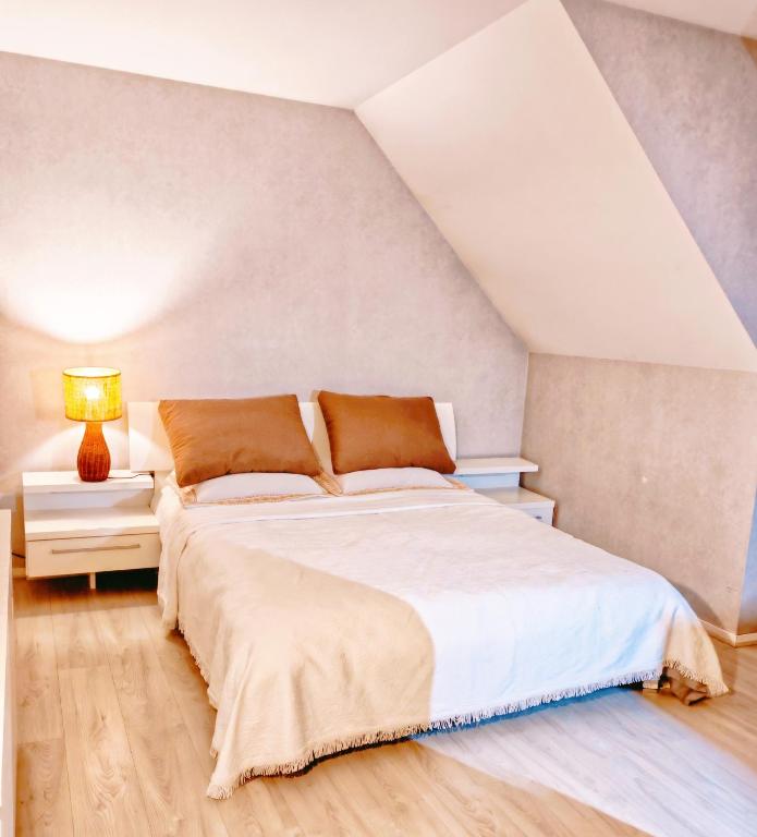 une chambre avec un grand lit dans un grenier dans l'établissement 玫瑰花苑, à Bussy-Saint-Georges