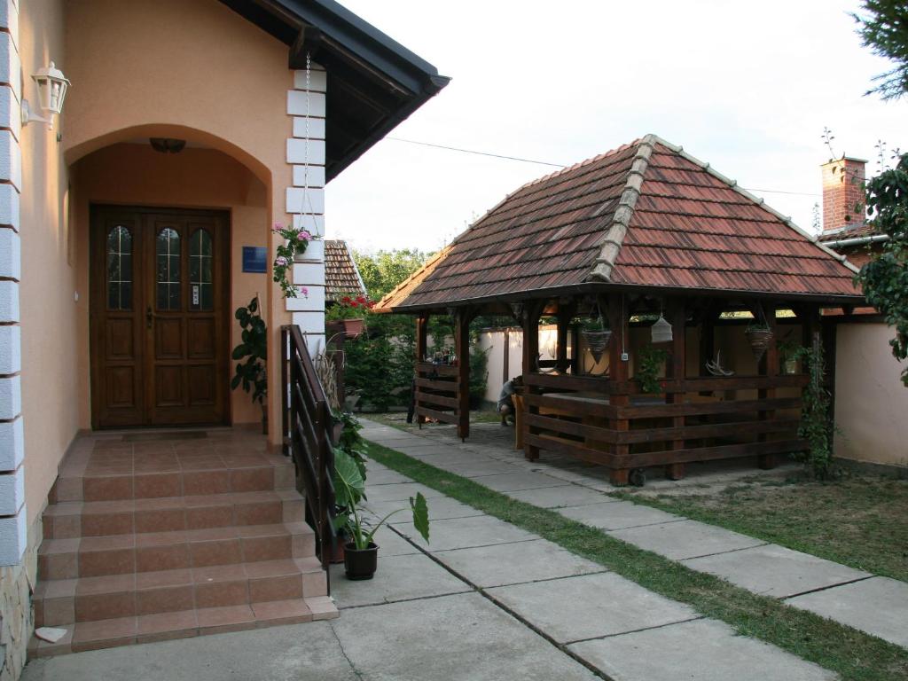 a building with a gazebo next to a house at Apartments Vrata Baranje in Bilje